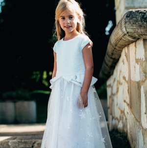 Disney Cinderella Dress with White Sequins and Glitter Stars worn by model child in a garden. This white Cinderella Dress by Disney Boutique is a fabulous choice for the wedding and party season. The dazzling white sequin bodice has a shaped sequin peplum and elegant sequin capped sleeves.