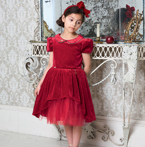 Girl wearing Disney Boutique Snow White Dress - This rich ruby velvet Snow White dress from Disney is adorned with a gold piped Peter Pan collar. It has pretty gathered short sleeves. The full velvet skirt has a high - low hemline revealing a red twinkling