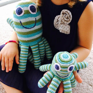 A lovable Octopus Soft Toy - Fair Trade Too This adorable blue and green striped Octopus soft toy makes a gorgeous gift for new babies, christenings and first Christmas. They are hand-knitted by a team of people in rural Bangladesh, as this is a fair trade toy all the workers are fairly paid. Beautiful bright colours.  Handmade, fair trade and adorable! Showing child with both octopus sizes