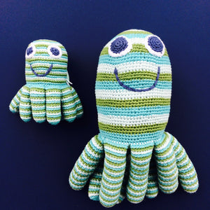 Brightly coloured Octopus Rattle Soft Toy - Fair Trade Too This adorable blue and green striped Octopus rattle soft toy makes a gorgeous gift for new babies, christenings and first Christmas. These cotton crochet toys are hand knitted by a team of people in rural Bangladesh, as this is a fair trade toy all the workers are fairly paid. Beautiful bright colours and a rattle sound when you shake the little octopus.  Octopus Rattle with Large Octopus soft toy on blue background