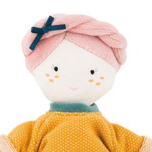 Moulin Roty Doll - French design, beautifully made, beloved gift! This soft 26cm Moulin Roty doll has a cheery expression, pink plaited velour hair with a black bow. She wears a bright orange jumper and white skirt. Her clothes are removable.  She will be a great addition to the family! Showing close up of doll's face
