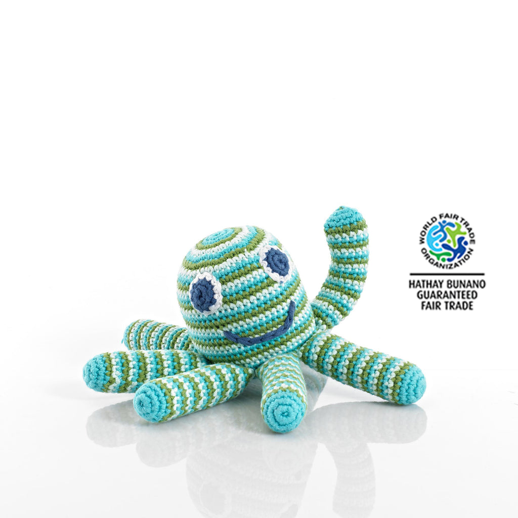 Brightly coloured Octopus Rattle Soft Toy - Fair Trade Too This adorable blue and green striped Octopus rattle soft toy makes a gorgeous gift for new babies, christenings and first Christmas. These cotton crochet toys are hand knitted by a team of people in rural Bangladesh, as this is a fair trade toy all the workers are fairly paid. Beautiful bright colours and a rattle sound when you shake the little octopus. Octopus showing on white background