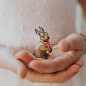 This rabbit necklace is so charming. This beautifully hand painted brown rabbit necklace is dressed with a pink bow. These hand painted necklaces have amazing detailed features that make the rabbit look adorable. You will treasure this gift for years to come - a real keepsake. Rabbit showing in model's hand