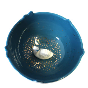 Aerial view of Swan Bowl. with glitter.  A lovely Swan Bowl - perfect for trinkets, jewellery or treats This elegant swan bowl depicts a pretty riverbank with floral designs decorating the outside of this bowl. Inside, there's a deep blue colour representing the water with gold dots glistening on the surface. A regal white swan wearing a gold crown, shelters at the bottom of the bowl.